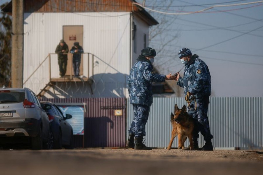 Law enforcement officers with a dog stand guard near a security checkpoint of the IK-2 corrective penal colony, where Kremlin critic Alexei Navalny serves his jail term, in the town of Pokrov, Russia April 6, 2021. REUTERS/Maxim Shemetov