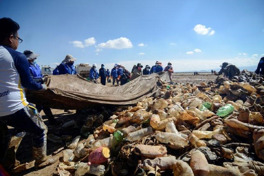 People clean lake Uru Uru from plastic waste during a cleaning activity with French influencer Alexis Dessard, in Oruro, Bolivia, April 7, 2021 — Reuters