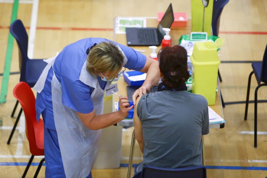 A woman receives an Oxford-AstraZeneca coronavirus disease (Covid-19) vaccine at a vaccination centre at Cwmbran Stadium in Cwmbran, South Wales, Britain on February 17, 2021 — Pool via Reuters