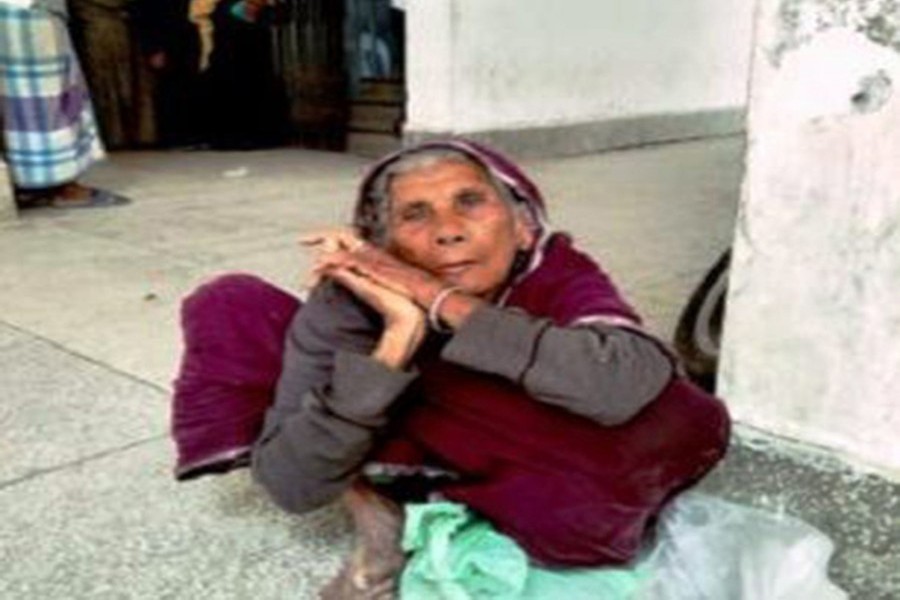 Moriomjan, a 100-year old woman, waited on the Deputy Commissioner office's corridor in Chandpur Sadar on Thursday morning with a govt slip in hand in the hope of getting relief rice — FE Photo