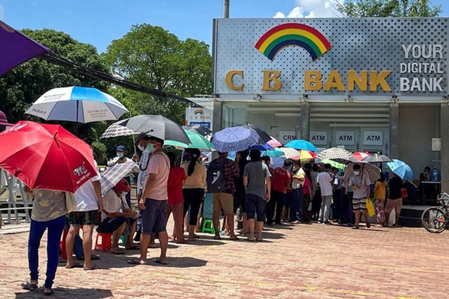 People line up outside a bank to withdraw cash, in Yangon on Thursday –Reuters photo  