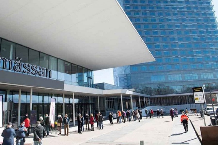 People stand in line to get a vaccine against the coronavirus disease (COVID-19) outside the Stockholmsmassan exhibition center, turned mass vaccination centre, in Stockholm, Sweden, April 8, 2021. Fredrik Sandberg/TT News Agency via REUTERS