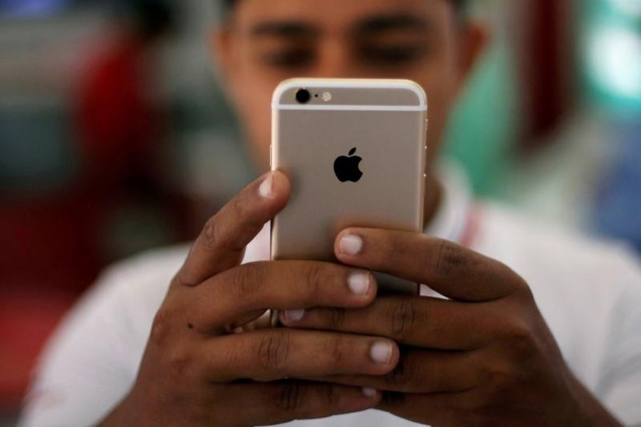 A salesman checks a customer's iPhone at a mobile phone store in New Delhi, India on July 27, 2016 — Reuters/Files