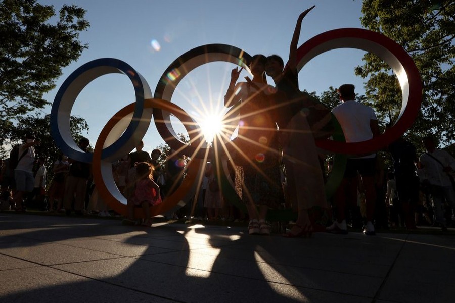 People pose for a photograph in front of an Olympic rings monument outside the National Stadium, the main stadium of Tokyo 2020 Olympic and Paralympic Games, amid the coronavirus disease — Reuters photo