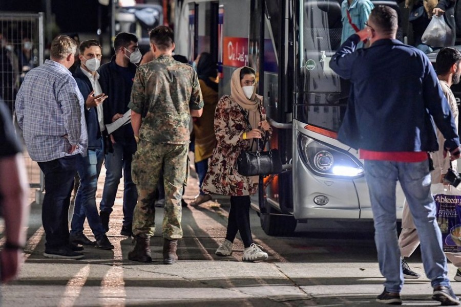 A woman who was evacuated from Kabul, Afghanistan walks with a bag after alighting from a bus upon arriving in Doberlug-Kirchhain, Germany on August 20, 2021 — Reuters photo