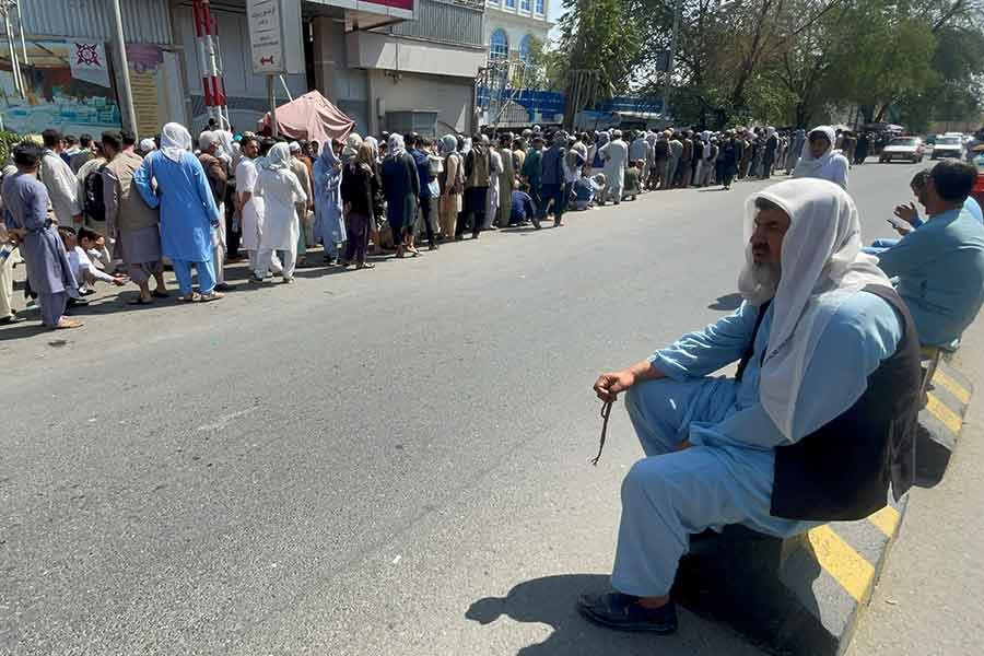 Afghans waiting outside a bank in Kabul in a long queue on September 1 this year to take out their money after Taliban takeover in Afghanistan -Reuters file photo