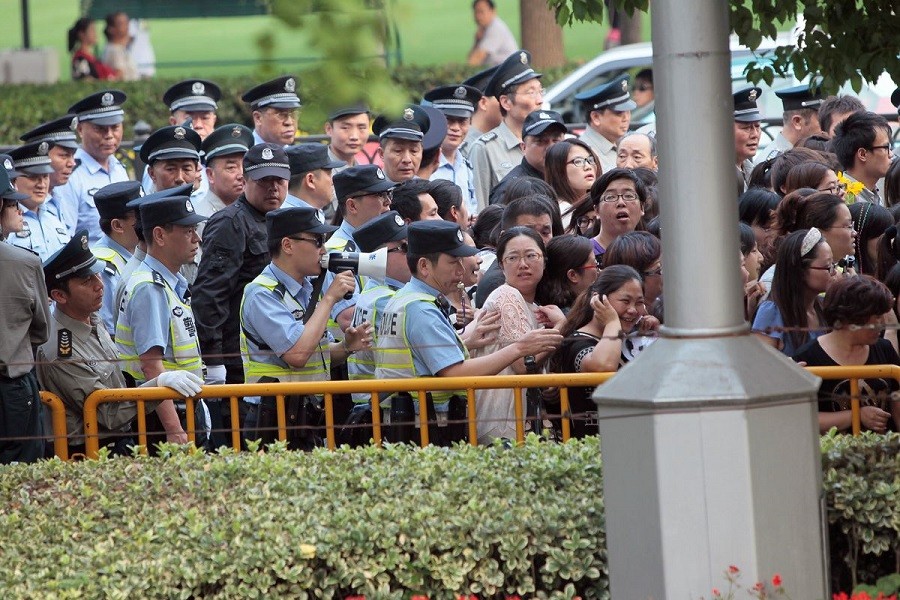 Police officers remove fans standing outside the opening ceremony of the 17th Shanghai International Film Festival, June 14, 2014 —Reuters/Aly Song (CHINA - Tags: ENTERTAINMENT)