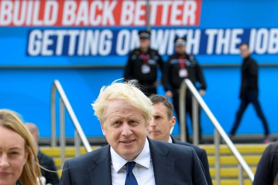 Britain's Prime Minister Boris Johnson walks through the Conservative Party annual conference venue, in Manchester, Britain, October 3, 2021. Reuters