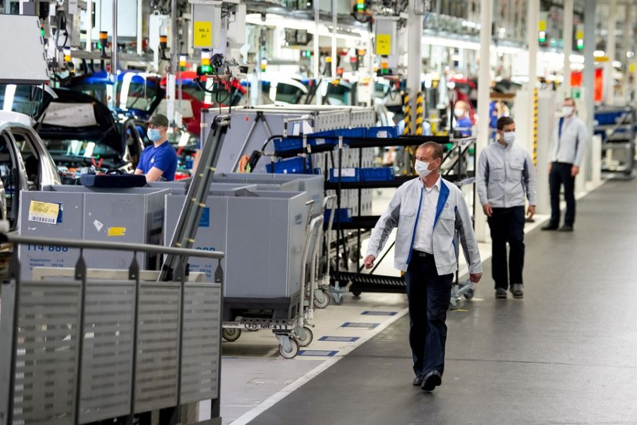 Staff wear protective masks at the Volkswagen assembly line in Wolfsburg, Germany, April 27, 2020. Swen Pfoertner/Pool via REUTERS