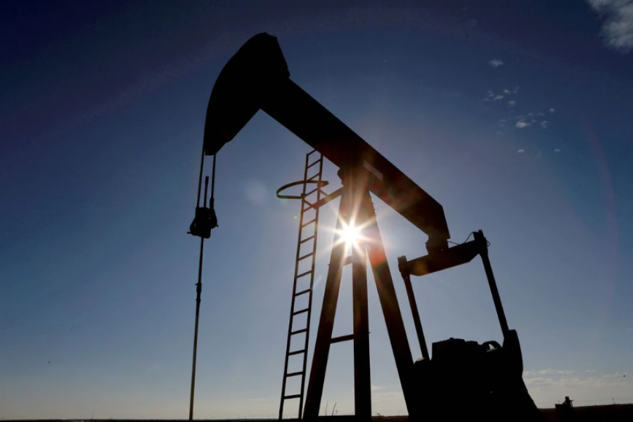 The sun is seen behind a crude oil pump jack in the Permian Basin in Loving County, Texas, US, November 22, 2019. REUTERS/Angus Mordant/File Photo