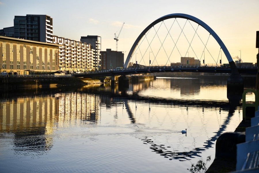 A swan floats as the early morning sun shines on the River Clyde and the venue for the UN Climate Change Conference (COP26) in Glasgow, Scotland Britain, November 10, 2021. REUTERS/Dylan Martinez