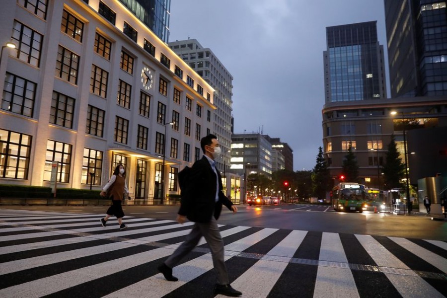 A pedestrian wearing a protective face mask crosses a street, amid the coronavirus disease (Covid-19) outbreak, in the business district in Tokyo, Japan on May 21, 2020 — Reuters/Files