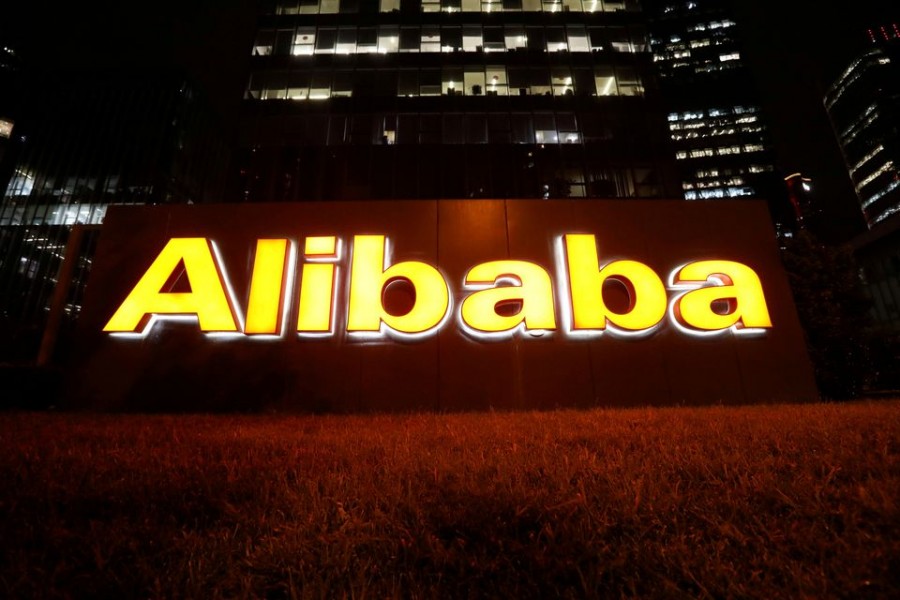 The logo of Alibaba Group is lit up at its office building in Beijing, China August 9, 2021. REUTERS/Tingshu Wang/File Photo