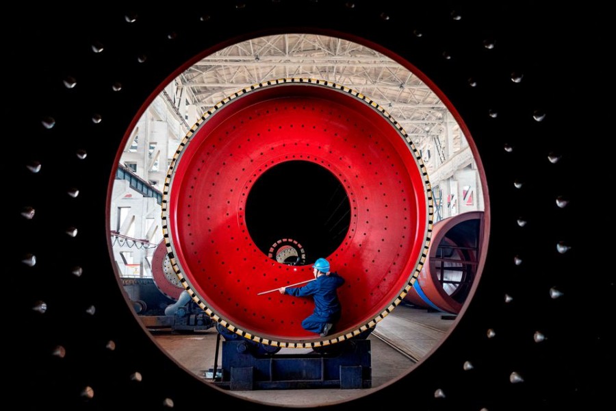 An employee measures a newly manufactured ball mill machine at a factory in Nantong, Jiangsu province on China June 28, 2019 — Reuters/Files