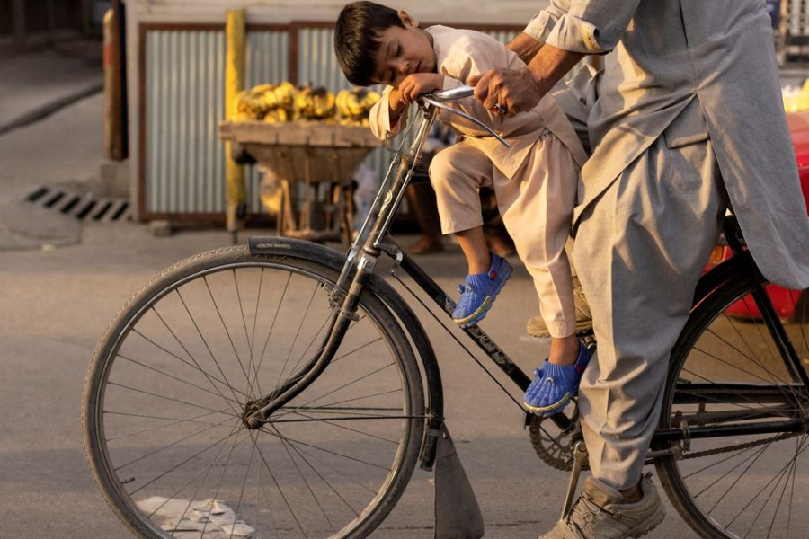 A boy sleeps as he rides a bicycle in Kabul, Afghanistan on October 18, 2021 — Reuters/Files