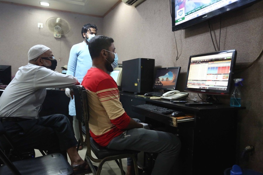 Traders, wearing masks, monitoring stock price movements on computer screens at a brokerage house in Dhaka city — FE/Files