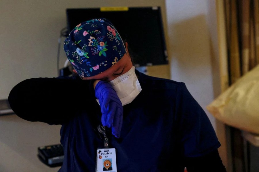 Registered nurse Patricia Thomas wipes a tear from her eye after tending to a deceased coronavirus disease (Covid-19) positive patient, whose relatives made the decision to take him off life support today, in the intensive care unit (ICU) at San Juan Regional Medical Center in Farmington, New Mexico, US on December 10, 2021