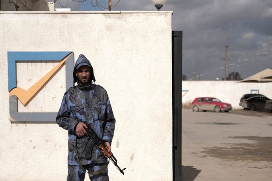 A security officer stands in front of the High National Election Commission building in Benghazi, Libya December 16, 2021. REUTERS/Esam Omran Al-Fetori/File Photo  Libya's parliament said Friday's planned presidential election would not go ahead, leaving the internationally backed peace process in chaos and the fate of the interim government in doubt.  The electoral commission proposed pushing back the voting date by a month, confirming a delay that had been widely expected amid ongoing disputes over the rules, including the eligibility of several divisive major candidates.  Disagreements showed the limitations of a winner-takes-all presidential vote involving candidates viewed as unacceptable in large parts of the country including the son of Muammar Gaddafi and a military leader who assaulted Tripoli.  At stake is a peace process that had been seen as the best hope in years of bringing an end to the decade of chaos and violence that has engulfed Libya since a NATO-backed uprising ousted Gaddafi in 2011.  Very large numbers of Libyans had already registered for voting cards for the election in what politicians on all sides in Libya have said is a sign of strong popular desire for a vote.  However, with mobilisations in Tripoli and other western areas by armed groups, the collapse of the electoral process risks aggravating local disputes and triggering a new round of fighting.  Disputes over the path forward could also undo the wider UN-backed peace process between Libya's main eastern and western camps that have maintained a ceasefire since last year.  Some figures in the east have warned of a new breakaway government that would return Libya to the division between warring administrations that lasted from the last election in 2014 until the installation of the current interim government.   Factions, candidates and foreign powers have been talking behind the scenes about whether an election can still take place with a short delay or whether a longer postponement is necessary to reach agreement on the legal basis of the vote.  UN special adviser Stephanie Williams said on social media she had been meeting members of the political forum that set the electoral process in train last year and reiterated the need for "free, fair and credible elections".  Meanwhile, the status of the interim government that was installed in March as part of the same peace process is also at risk, with the eastern-based parliament having withdrawn confidence from it in September.  DISPUTES  The electoral committee's statement on Wednesday added that the government's mandate would expire on Friday. However, other main factions and political institutions may stick with the government, which is also recognised by the United Nations.  The election was originally called through a UN-backed roadmap that envisaged simultaneous parliamentary and presidential elections on Dec 24 - Libya's national day.  However, there was no agreement on the constitutional basis for the election or on the rules among the country's fragmented political institutions.   In September the speaker of parliament Aguila Saleh, himself a presidential candidate, issued a law that his critics said was not properly passed through the chamber, deviated from the roadmap and was crafted to benefit himself and his allies.  That law, which split the presidential election from a later parliamentary one, formed the basis of the electoral process, although powerful factions and leading candidates rejected it.  With little agreement on the rules, or on who would enforce them or adjudicate disputes, the entry of highly divisive candidates into the presidential race triggered the collapse of the process.  Electoral commission head Emad Sayeh said in a statement that the process had run into trouble because the rules were not adequate to handle appeals and disputes over eligibility.  The three most prominent candidates, eastern commander Khalifa Haftar, Saif al-Islam Gaddafi and interim Prime Minister Abdulhamid al-Dbeibah, were also the three most divisive.  Haftar was unacceptable to many in western Libya after his 2019-20 assault on Tripoli that smashed parts of the capital. Gaddafi was convicted of war crimes by a Tripoli court and is detested by many of those who fought in the 2011 revolt.  Dbeibah had promised when he was installed as premier that he would not run in an election and his continued work as prime minister in the run-up to the vote led many of his rivals to say he had an unfair advantage.