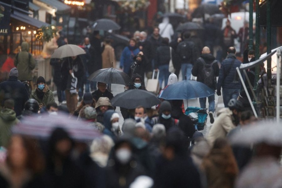 People wearing protective masks are pictured on a rainy winter day in the Montorgueil street, amid the spread of the coronavirus disease (COVID-19) pandemic, in Paris, France, December 27, 2021 – Reuters