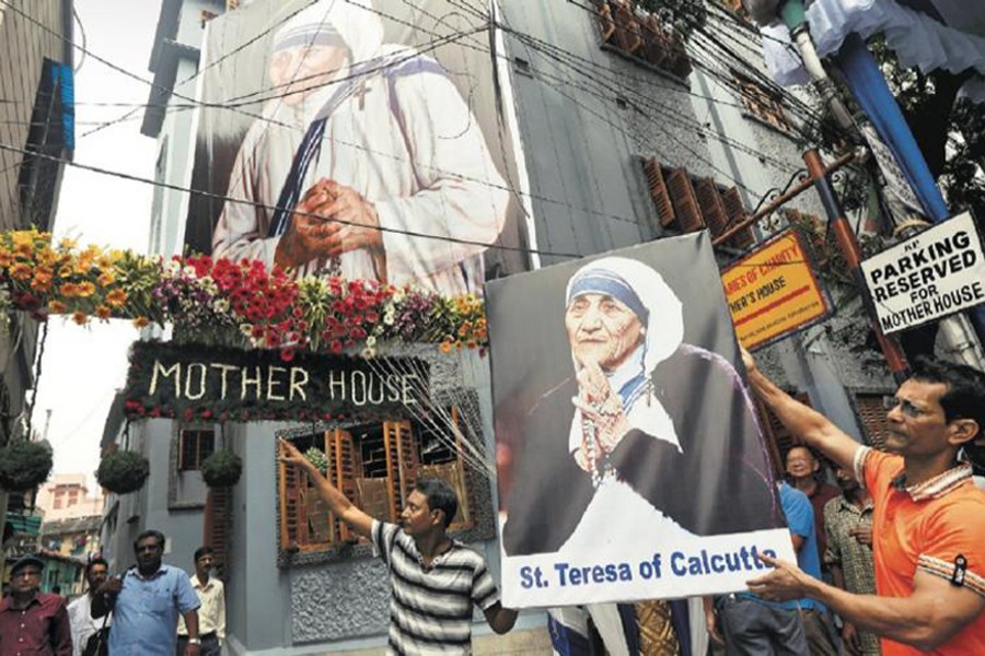 A man holds a poster of Mother Teresa outside the Missionaries of Charity building in Kolkata as she was canonised during a ceremony held in the Vatican, India on September 4, 2016 — Reuters/Files