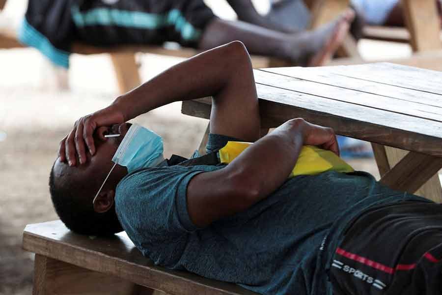 A migrant from Haiti taking rest on a bench at a migrant camp in Darien province of Panama on August 6 in 2021 -Reuters file photo