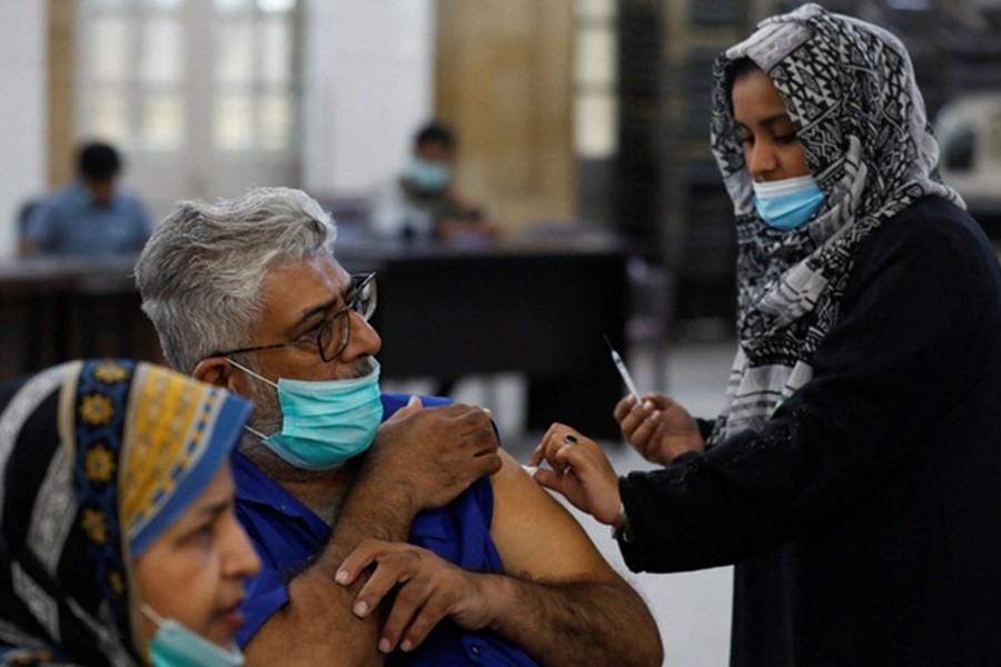 A healthcare worker administers a dose of the coronavirus disease (COVID-19) booster vaccine at a vaccination centre in Karachi, Pakistan Dec 15, 2021. REUTERS