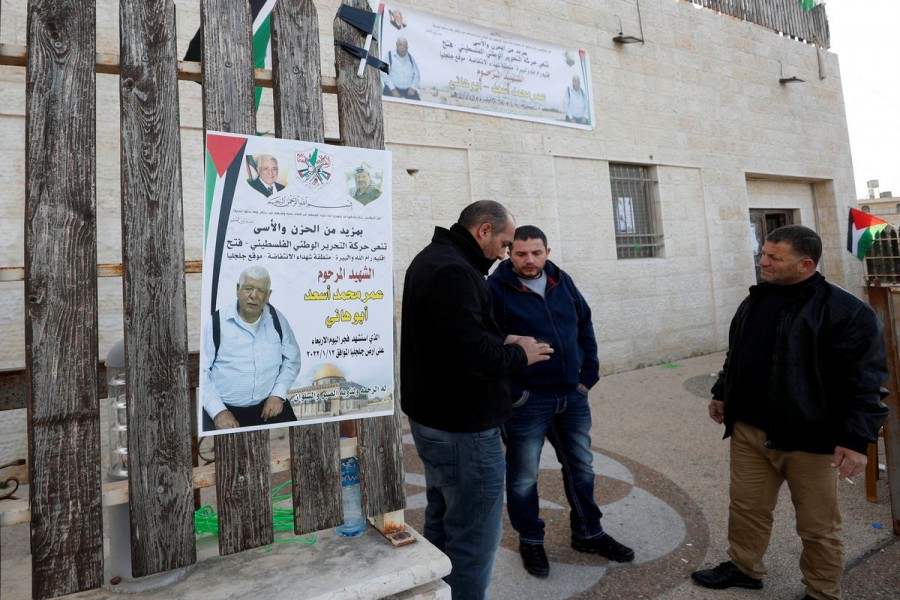 Men stand next to a poster of Palestinian Omar Abdalmajeed As'ad, 80, in Jiljilya village in the Israeli-occupied West Bank January 12, 2022. REUTERS/Mohamad Torokman