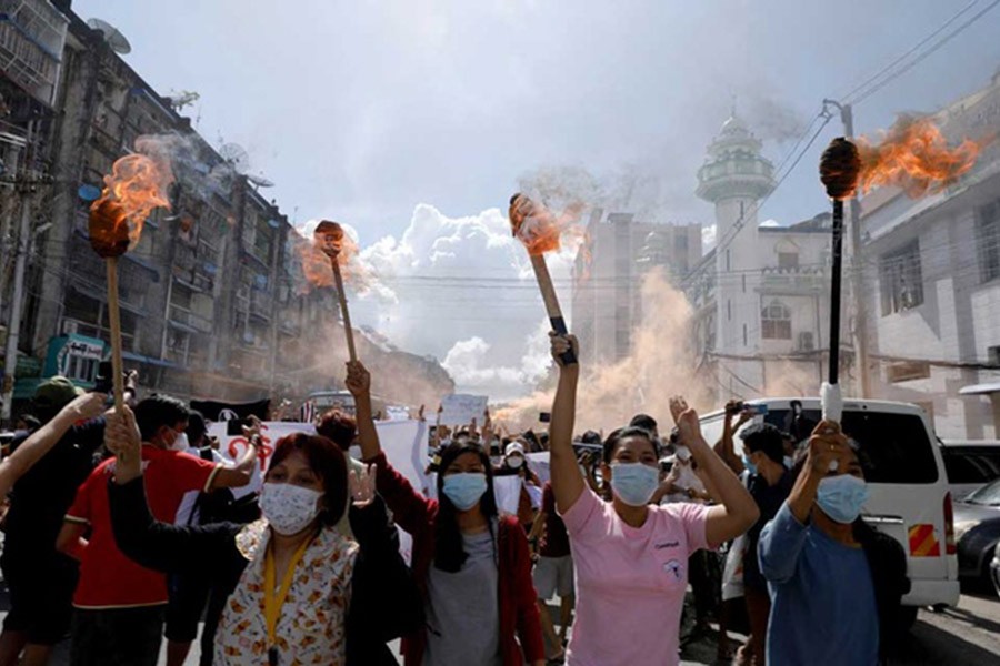 FILE PHOTO: A group of women hold torches as they protest against the military coup in Yangon, Myanmar July 14, 2021. REUTERS/Stringer/File Photo