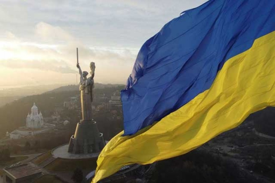 Ukraine's biggest national flag on the country's highest flagpole and the giant 'Motherland' monument are seen at a compound of the World War II museum in Kyiv, Ukraine, Dec 16, 2021. REUTERS/Valentyn Ogirenko