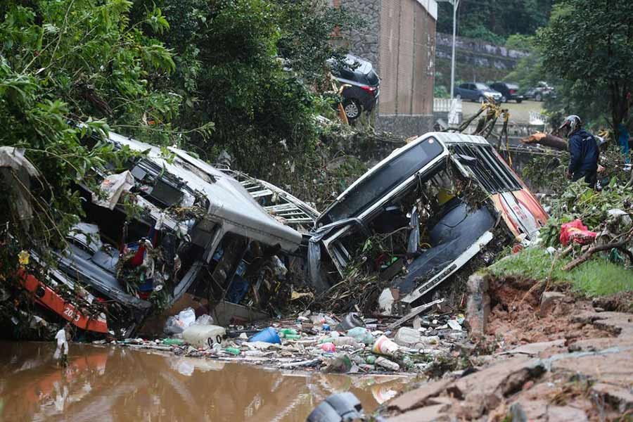 A man observing damaged public buses at a river after pouring rains in Petropolis of Brazil on Wednesday –Reuters photo