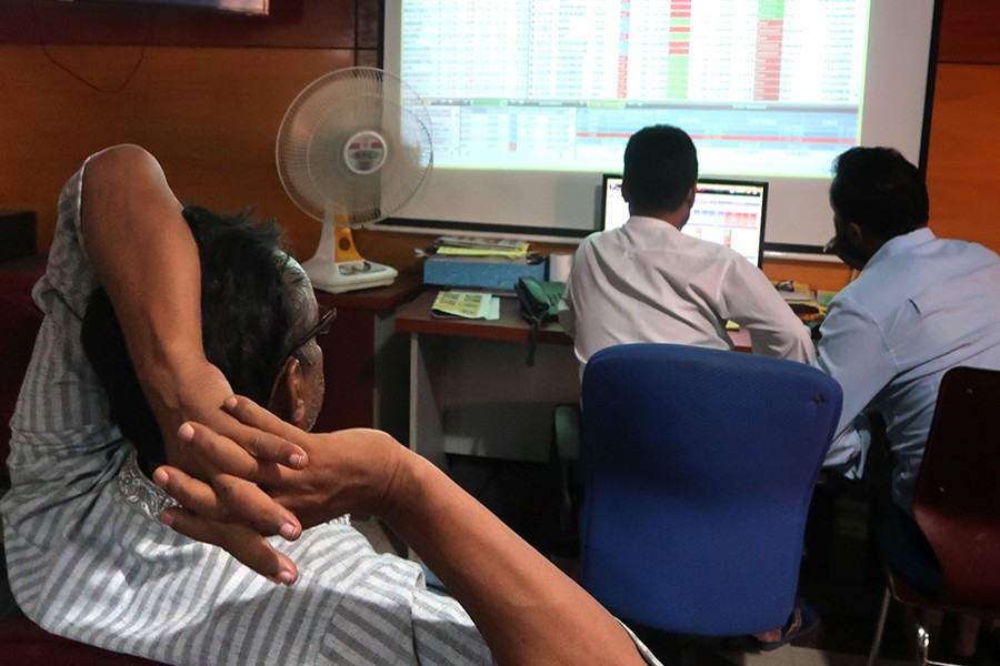 Investors monitoring stock price movements on computer and TV screens at a brokerage house in the capital city — FE/Files