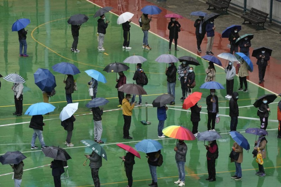 Residents line up to get tested for the coronavirus at a temporary testing center despite the rain in Hong Kong, Tuesday, Feb. 22, 2022. Hong Kong will test its entire population for COVID-19 in March, the city’s leader said Tuesday, as the city grapples with its worst outbreak driven by the omicron variant.(AP Photo/Kin Cheung)