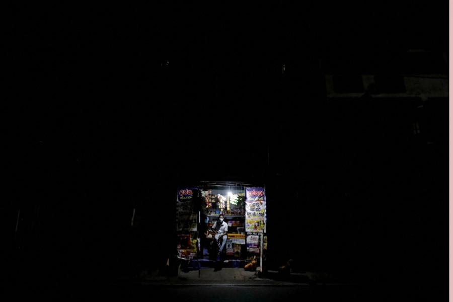 A vendor is seen inside his shop during a power outage in a suburb town in Colombo, Sri Lanka on February 24, 2022 — Reuters photo