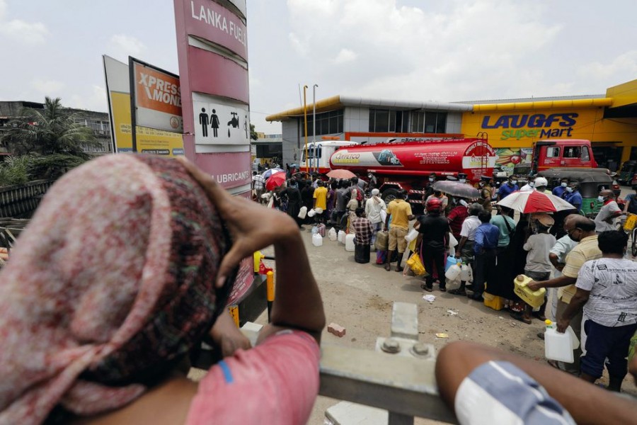 People stand in a long queue to buy kerosene oil for kerosene cookers amid a shortage of domestic gas due to country's economic crisis, at a fuel station in Colombo, Sri Lanka March 21, 2022. REUTERS/Dinuka Liyanawatte