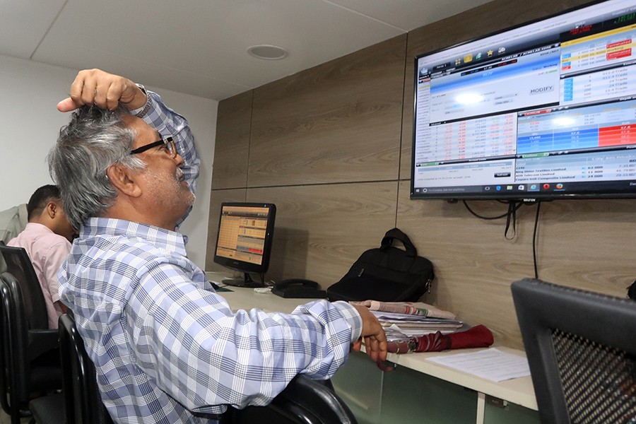 Investors monitoring stock price movements on computer and TV screens at a brokerage house in the capital city — FE/Files