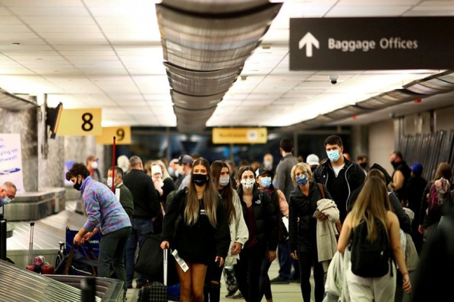 Travellers wearing protective face masks to prevent the spread of the coronavirus disease (COVID-19) reclaim their luggage at the airport in Denver, Colorado, US, November 24, 2020 – Reuters/Files