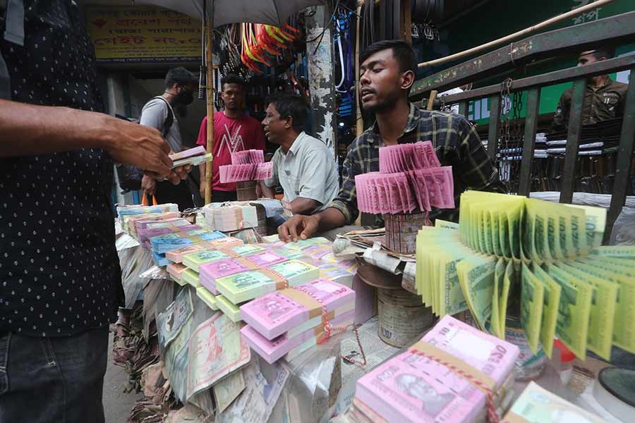 The trade in new currency notes is underway at Gulistan in Dhaka on Tuesday. Though this is a common sight in the area throughout the year, the currency business draws a crowd ahead of Eid as people buy the fresh notes to be given as gifts during the festival —FE photo