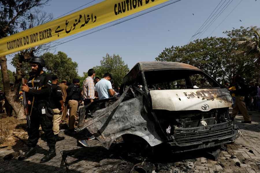 Police and security officers gathering near a passenger van after a blast at the entrance of the Confucius Institute University of Karachi of Pakistan on Tuesday –Reuters photo