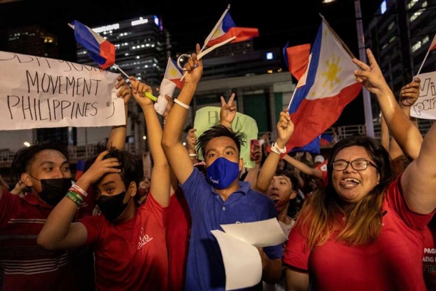 Supporters of presidential candidate Ferdinand "Bongbong" Marcos Jr celebrate as partial results of the 2022 national elections show him with a wide lead over rivals, outside the candidate's headquarters in Mandaluyong City, Philippines, May 9, 2022 – Reuters