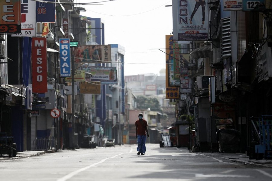 A man walks along a deserted road in Colombo, Sri Lanka, May 11, 2022. REUTERS/Dinuka Liyanawatte