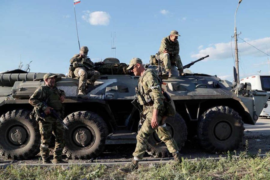 Service members of pro-Russian troops wait before the expected evacuation of wounded Ukrainian soldiers from the besieged Azovstal steel mill in the course of Ukraine-Russia conflict in Mariupol, Ukraine May 16, 2022. REUTERS/Alexander Ermochenko/File