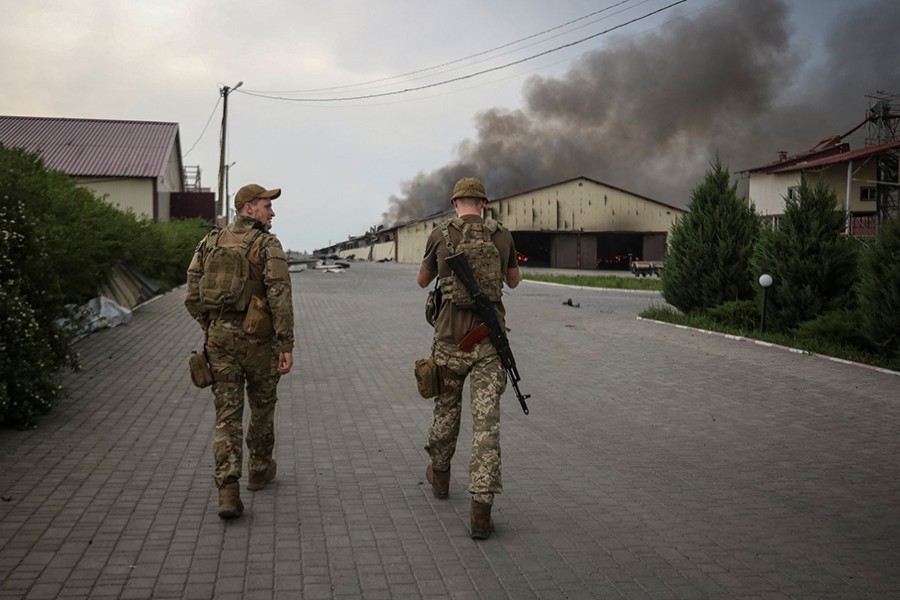 Ukrainian servicemen walk as seeds burn in a grain silos after it was shelled repeatedly, amid Russia's invasion of Ukraine, in Donetsk region, Ukraine on May 31, 2022 — Reuters photo