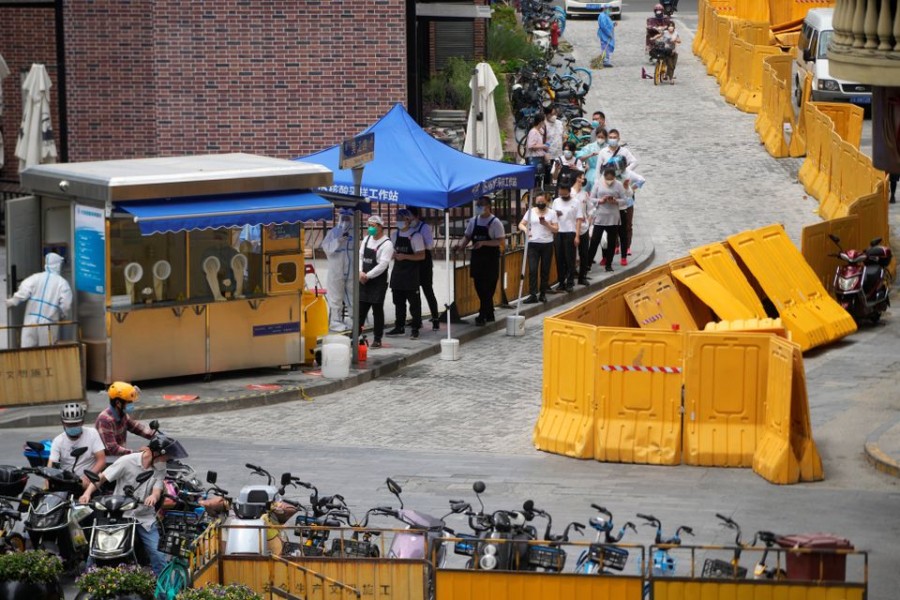 Restaurant workers line up at a nucleic acid testing booth, after the lockdown placed to curb the coronavirus disease (COVID-19) outbreak was lifted in Shanghai, China June 1, 2022. REUTERS/Aly Song