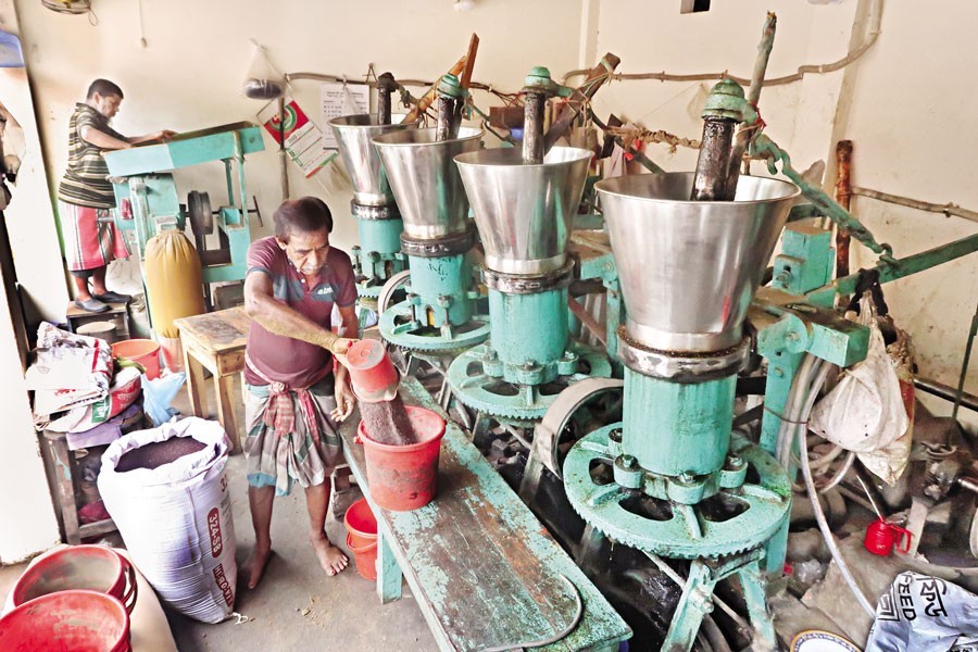 Workers at a motor-driven ghani (oilseed crushing machine) in the city passing busy time as the demand for mustard oil has gone up following an unabated hike in soybean oil price in recent months. The locally-made mustard oil is sold at Tk 270 per litre. The photo was taken on Thursday — FE photo by Shafiqul Alam