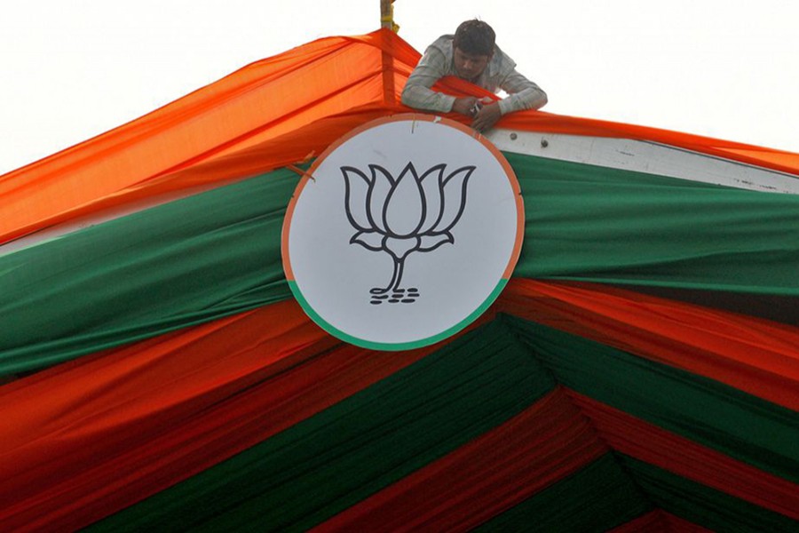 A man installs the symbol of India's ruling Bharatiya Janata Party (BJP) on a tent during an election campaign rally by the party in Prayagraj, India on February 24, 2022 — Reuters/Files