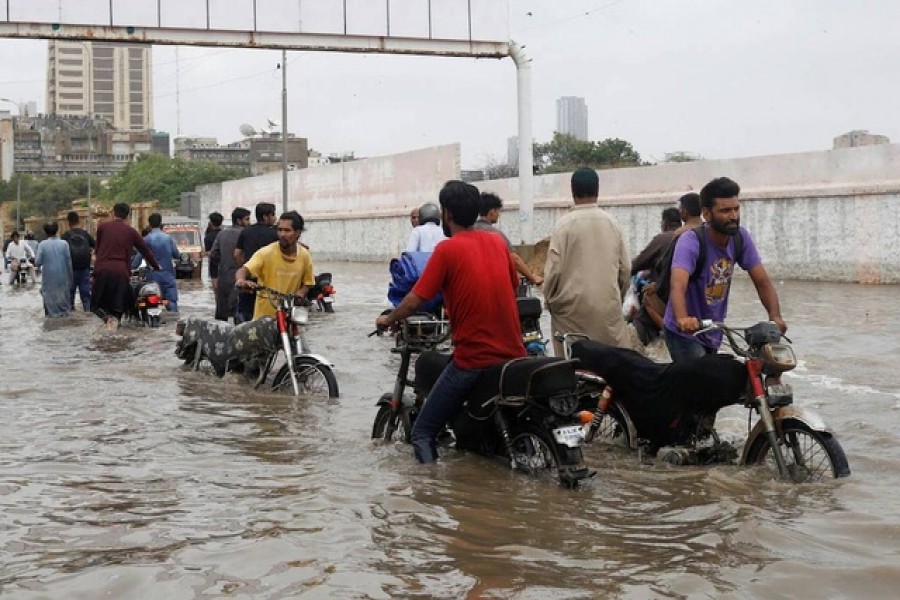 Residents commute through a flooded road during the monsoon season in Karachi, Pakistan Jul 9, 2022. Reuters