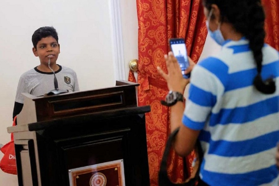 A boy poses for a photo on a podium at the President's house on the following day after demonstrators entered the building, after President Gotabaya Rajapaksa fled, amid the country's economic crisis, in Colombo, Sri Lanka July 10, 2022. REUTERS