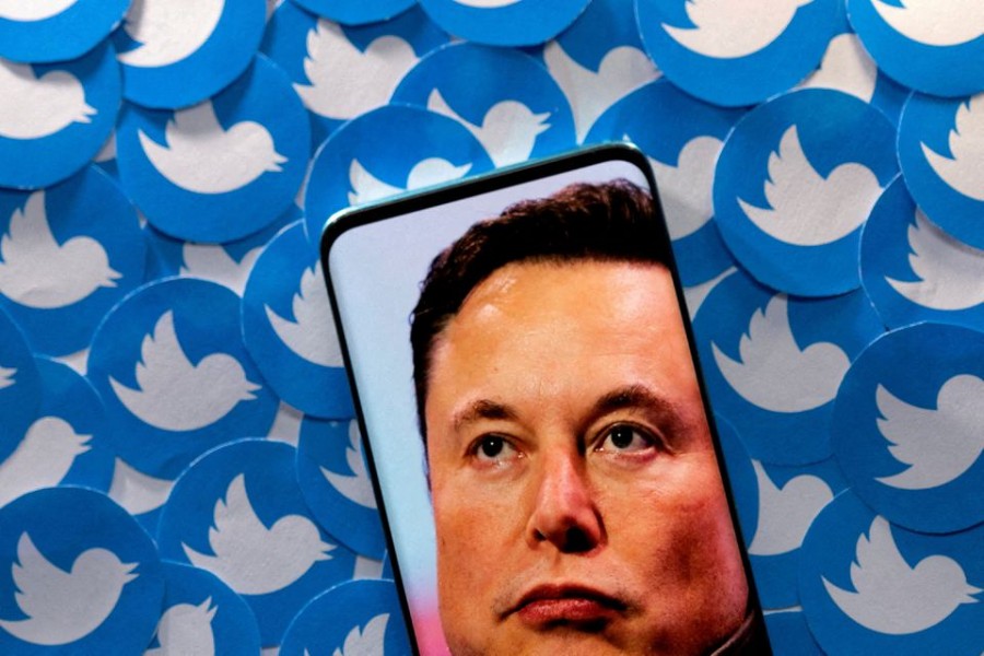 An image of Elon Musk is seen on smartphone placed on printed Twitter logos in this picture illustration taken April 28, 2022. REUTERS/Dado Ruvic/Illustration//File Photo