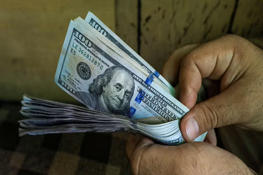 A trader counts US dollar banknotes at a currency exchange booth in Peshawar, Pakistan Sept 15, 2021. REUTERS