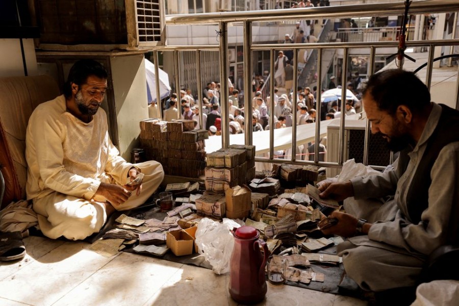 Afghan currency exchange workers count money at a market in Kabul, Afghanistan October 7, 2021. REUTERS/Jorge Silva